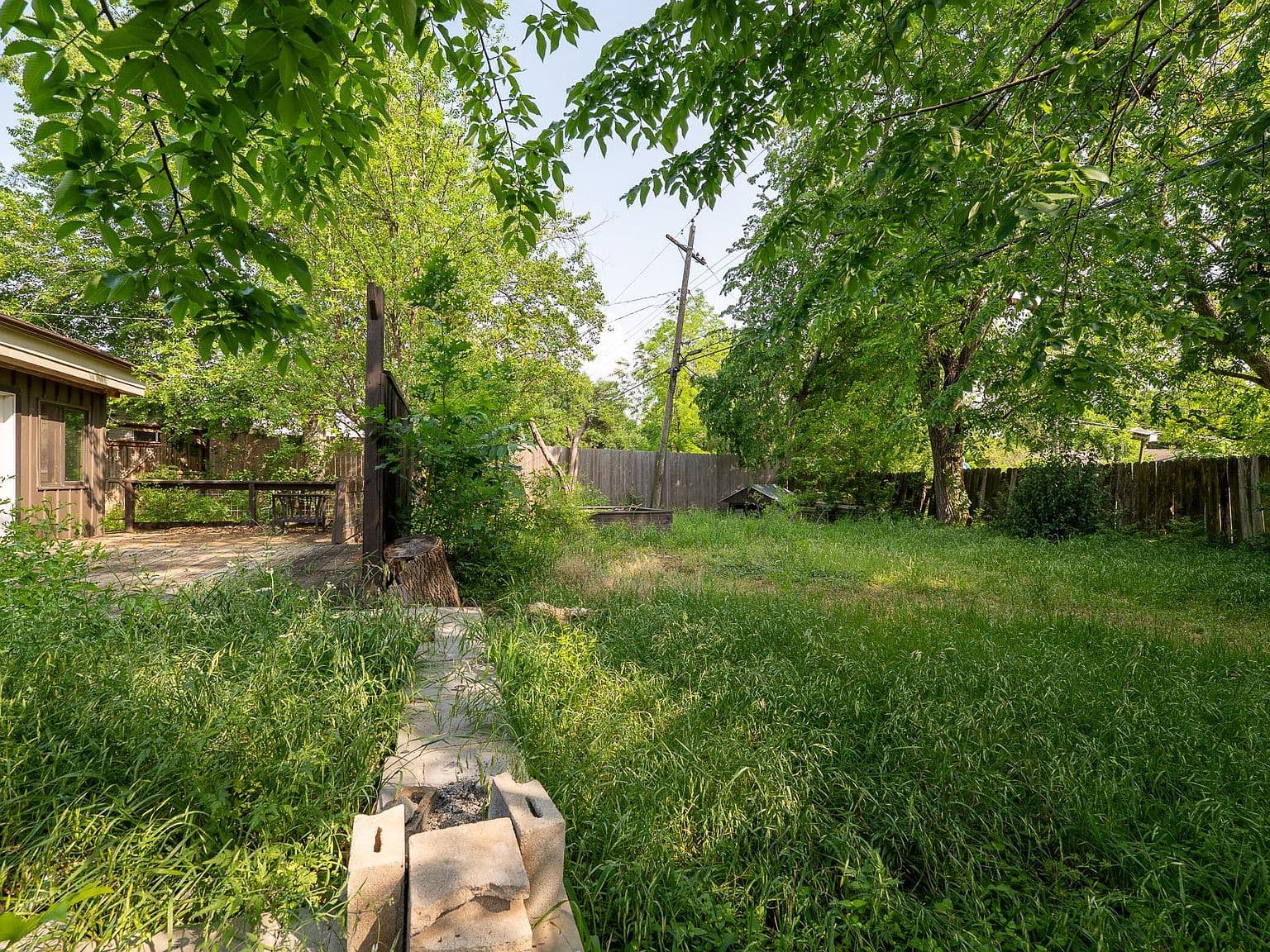 Overgrown Backyard and Damaged Deck