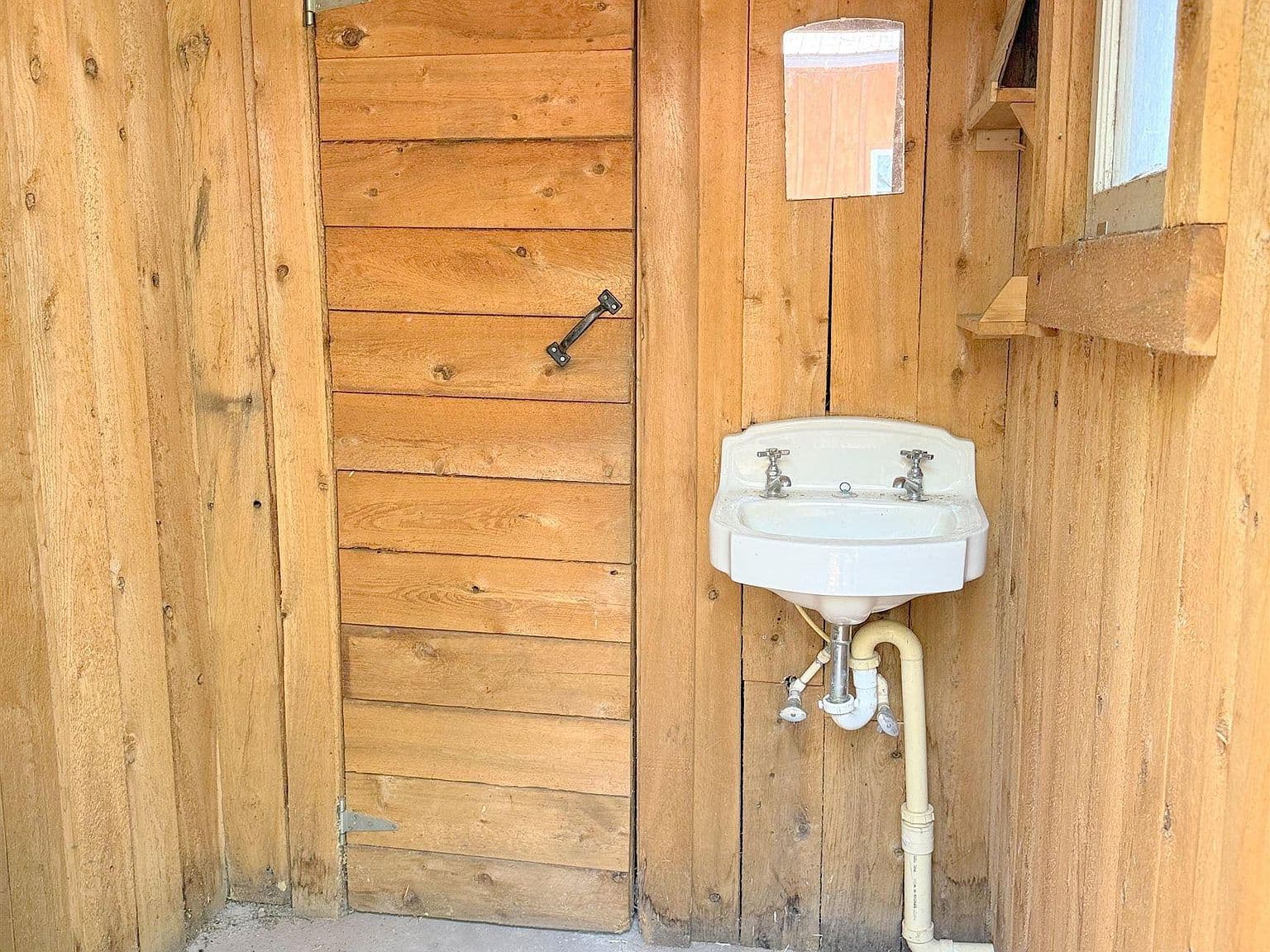 Exposed Plumbing in Outhouse